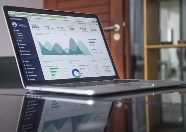 Laptop displaying a digital analytics dashboard with real-time data charts and metrics